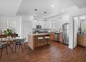 Thumbnail 9 of 9 - A modern kitchen with a wooden floor and stainless steel appliances.