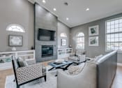 Thumbnail 8 of 8 - A living room with a grey couch and a fireplace.
