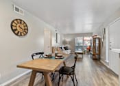 Thumbnail 12 of 27 - Open concept living and dining area with wood style flooring at The Colony Apartments, Texas, 78148