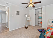 Thumbnail 16 of 27 - Bedroom with ceiling fan and open closet shelving at The Colony Apartments, Texas