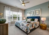 Thumbnail 4 of 21 - Bedroom. Big bed with two nightstands, light carpet, dresser, big windows, and ceiling fan at Ascent at Mallard Creek Charlotte, NC