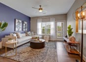 Thumbnail 2 of 21 - Living room with hard wood floors, couch, rug, tables and big windows.