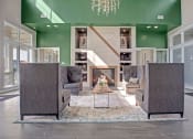 Thumbnail 18 of 21 - Lobby area that has couch like chairs, table in the center, fire place, dark concrete like floors, and big windows at Ascent at Mallard Creek Apartments in Charlotte, NC