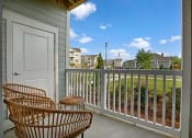 Thumbnail 6 of 21 - Balcony with two patio chairs and a table. Storage space on balcony at Ascent at Mallard Creek Charlotte, NC