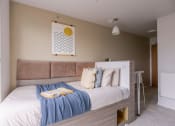 Thumbnail 1 of 8 - a bedroom with a bed and a desk