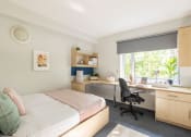 Thumbnail 7 of 8 - a bedroom with a bed and a desk with a chair