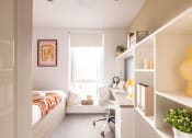 Thumbnail 3 of 8 - a small bedroom with a desk and a window