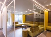 Thumbnail 7 of 8 - a lobby with yellow couches and a table