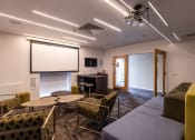 Thumbnail 8 of 8 - a room with a couch and tables and a projector