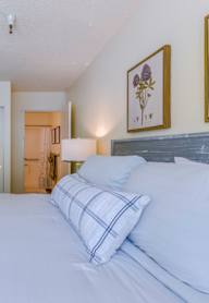 A bedroom with a large bed and two doors.