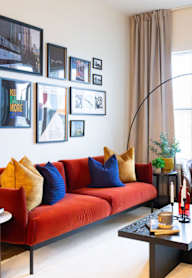 A living room with a red couch and a coffee table.