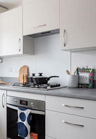a modern kitchen with grey cabinets and black appliances