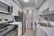 A modern kitchen with stainless steel appliances and white cabinets.