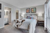 A bedroom with a large bed and two lamps.