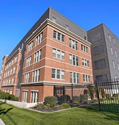 a tall brick building with a fence in front of it