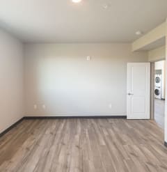 an empty living room with wood flooring and a white door