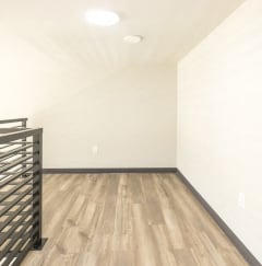 a bedroom with white walls and wood flooring and a bunk bed