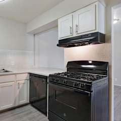 A kitchen with a black stove and white cabinets.