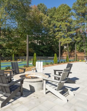 the reserve at bucklin hill fire pit and seating area with tennis courts in the background at Elme Cumberland Apartments, Smyrna, GA, 30080
