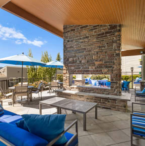the outdoor patio has a fireplace and tables with umbrellas