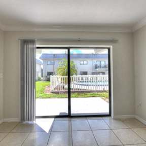 an empty living room with sliding glass doors to a yard