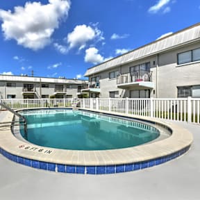 A swimming pool in a residential area with buildings in the background.