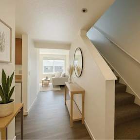A staircase with a white railing and a round mirror on the wall.