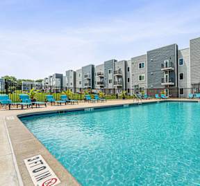 A swimming pool in front of apartment buildings.