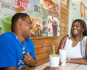a man and a woman sitting at a table in a fast food restaurant