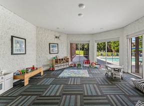 A room with a striped couch and a rug with a table and chairs.