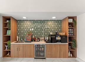 A kitchen with wooden cabinets and a green patterned backsplash.
