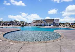 A large outdoor swimming pool with a building in the background.