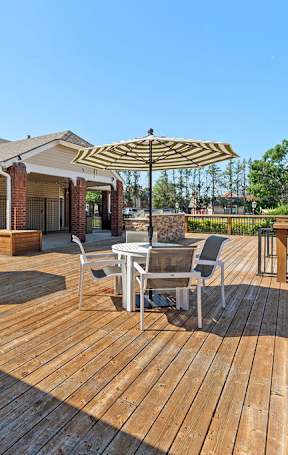 the preserve at ballantyne commons outdoor deck with a grill and table with chairs