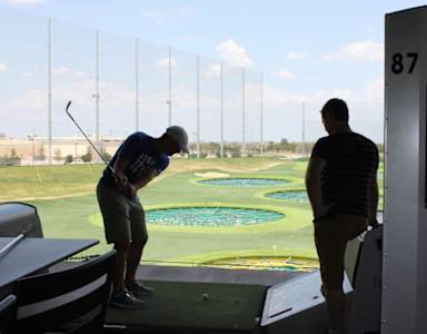 A man is practicing golf on a putting green.