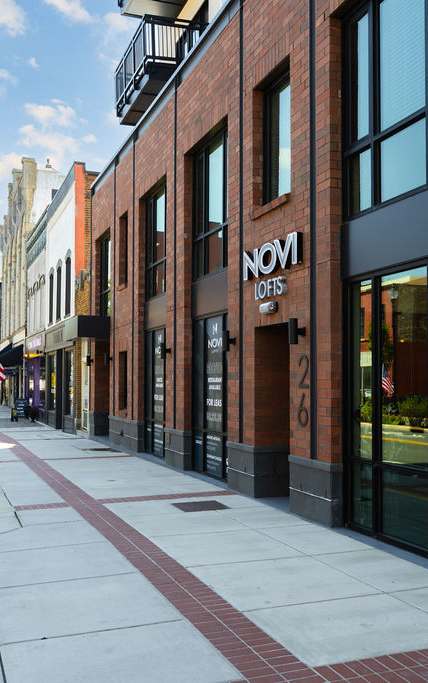 A brick building with a sign that says "NOMA Offers" on it.