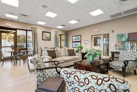 A living room with a wooden table and white couches.