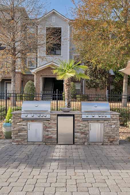 a brick patio with lounge chairs and barbecue grills at Echo at Lake Norman, Mooresville, NC