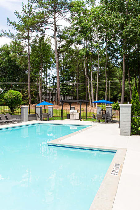 our apartments have a swimming pool with chairs and umbrellasat The Hub at 934 Apartments, Georgia, 30349
