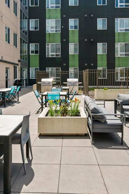 A patio with a table and chairs is surrounded by a fence.