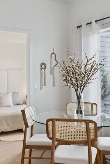 a bedroom with a bed and a dining room with a table and chairs