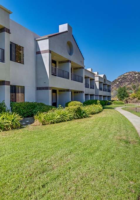 A reception area with a checkered floor and a wooden counter. at Legacy Hills at Poway 55+ Apartments, Poway