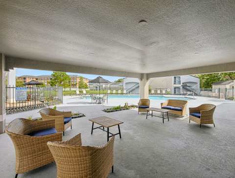 Clubhouse lounge with couches, chairs, coffee table, tiled flooring, and multi speed ceiling fan