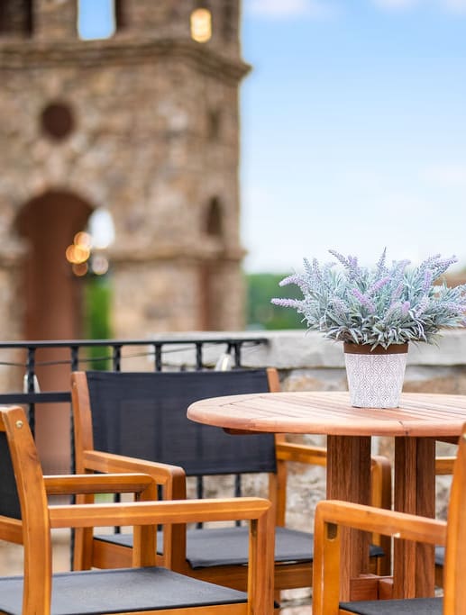 a table with a vase of flowers on a balcony