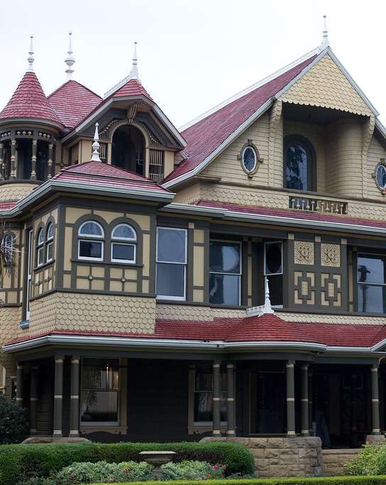 an old house with a red roof and a statue in front of it