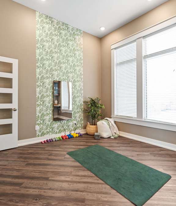 A room with a green rug on the floor and a white door on the left.