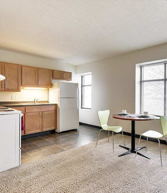 A kitchen area with a table and chairs by a window.