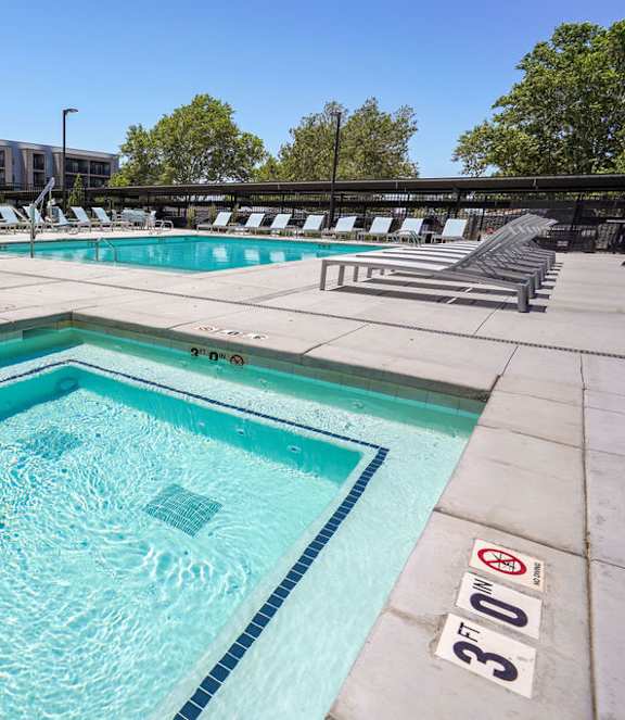 A swimming pool with a blue tiled edge and a red and white sign on the side.