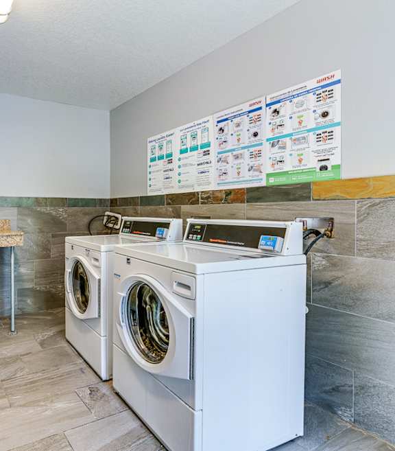 A laundry room with a washer and dryer and a counter top.