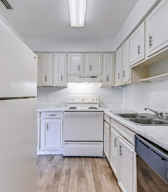 A kitchen with white cabinets and appliances.