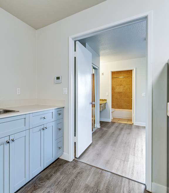 an empty kitchen with blue cabinets and a sink